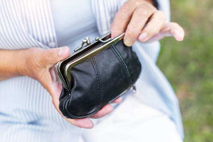 Hands of an elderly woman holding a purse