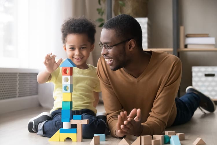 A father and son building a tower out of blocks.