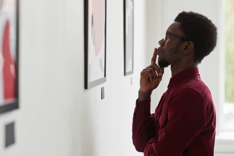 A man looking at art in a gallery.