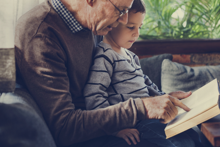 A grandfather reading a book with his grandson.