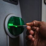 Someone inserting a card into an ATM.