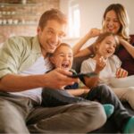 A young family watching TV together.