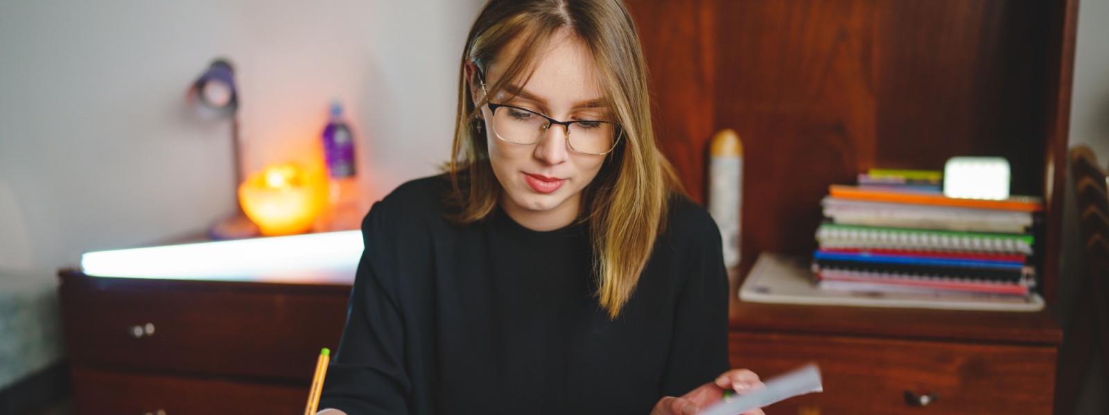 A young woman writing in a notebook.