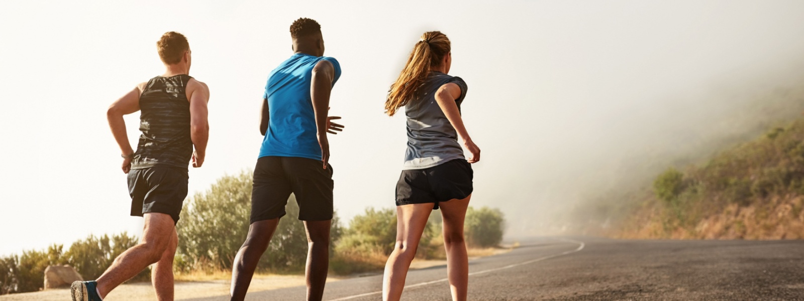 Three people running outdoors.