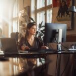 A woman using a computer in an office.