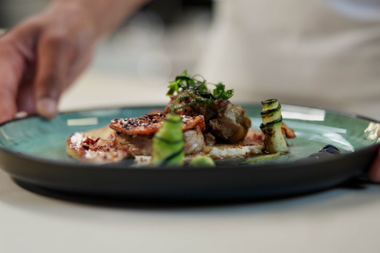 A chef prepares a dish in a fine dining restaurant.