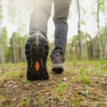 A close-up of a person walking in the woods.