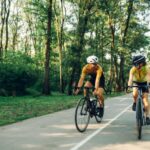 A couple cycling together on a road.