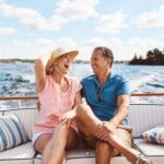 A couple in their 50s laughing on a boat together.