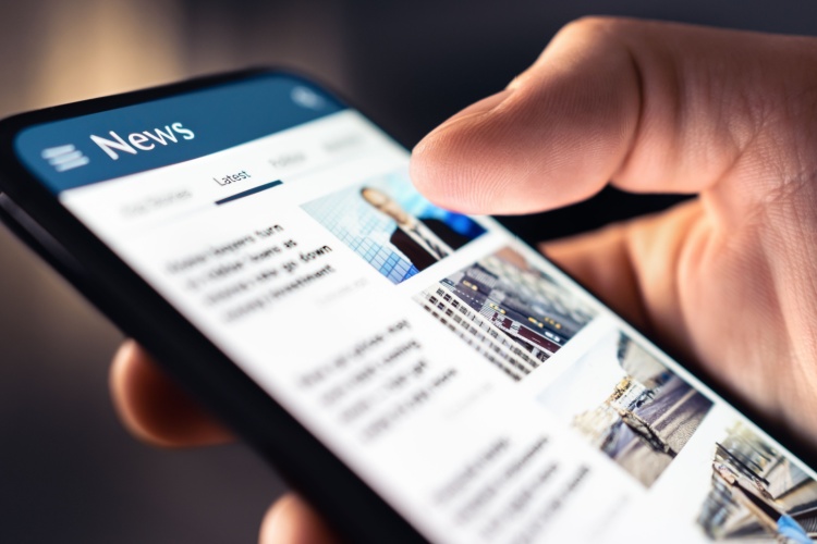 A person looking at a news feed on their phone.