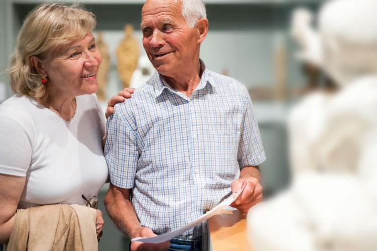A couple looking at a statue in a museum.