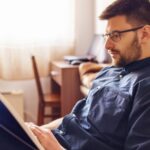 A man reading a book in his home.