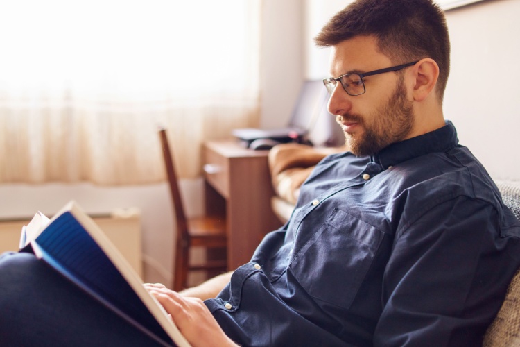 A man reading a book in his home.