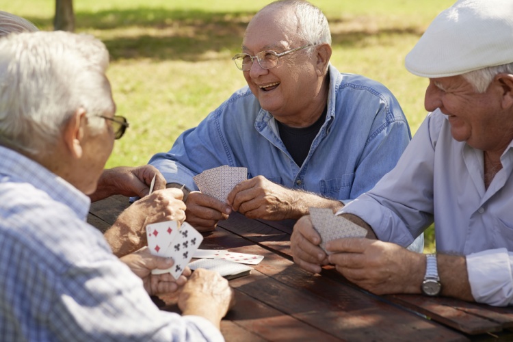 A group of friends playing cards outdoors.