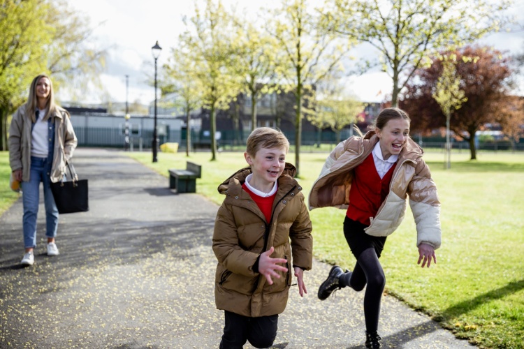 A mum and two children walking home from school.