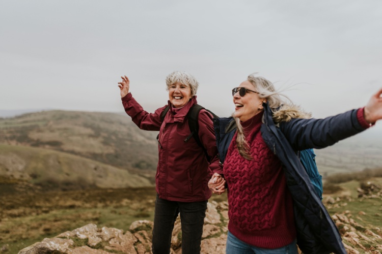 Two women laughing together during a hike.