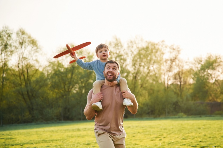 A father with a child sitting on his shoulders.