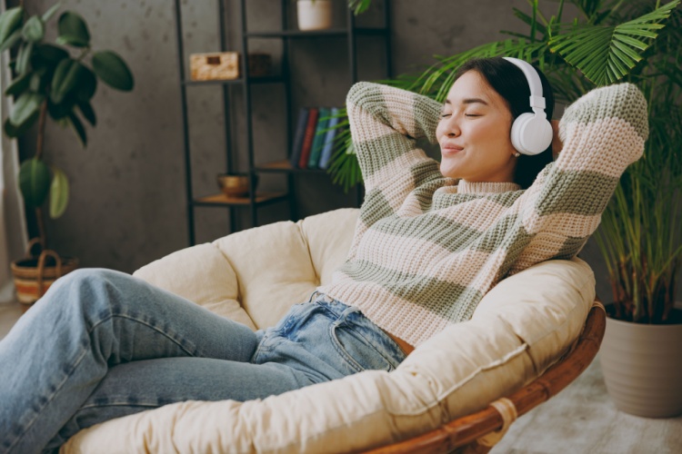 A woman relaxing with headphones on.