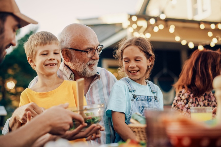 A grandfather laughing with his grandchildren.