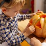 A child carving a pumpkin.