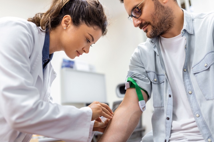 A doctor preparing to draw blood from a man.