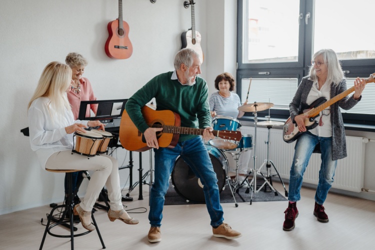 A group of people in their 50s playing musical instruments in a band.