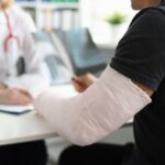 A man with a broken arm speaking with a doctor.