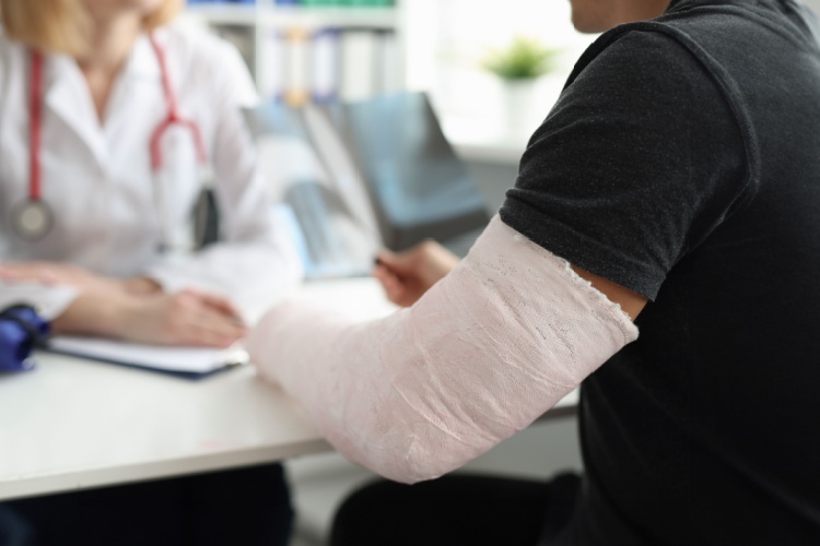 A man with a broken arm speaking with a doctor.