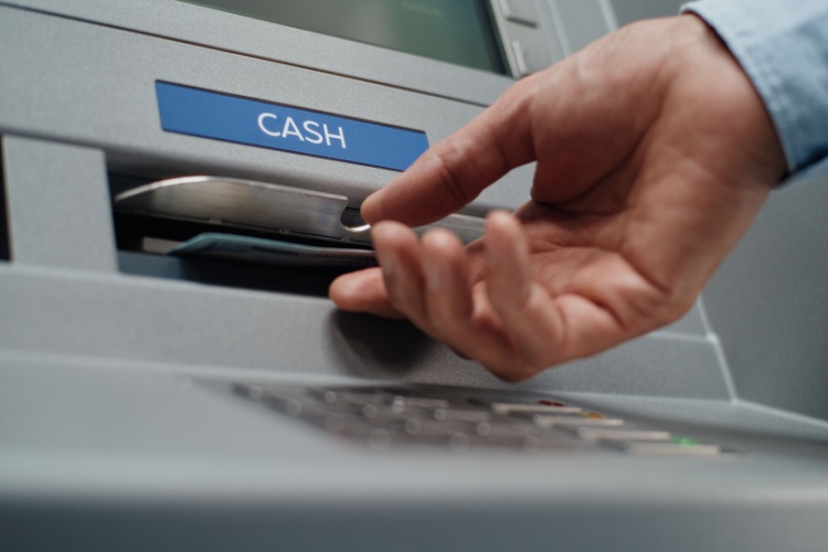 A person using an ATM to withdraw cash.