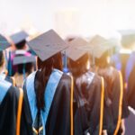 University students graduating wearing caps and gowns.