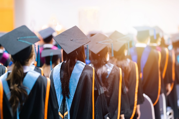 University students graduating wearing caps and gowns.