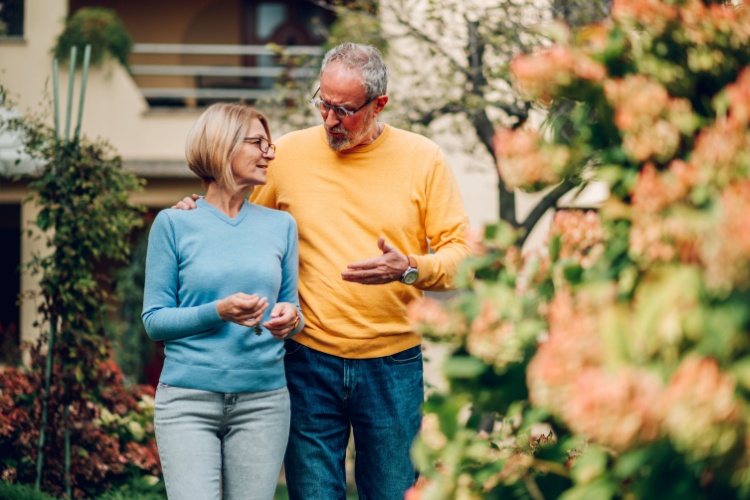 Mature couple walking outside a house
