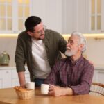 A father and son talking in a kitchen.