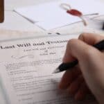 A person signing a will.