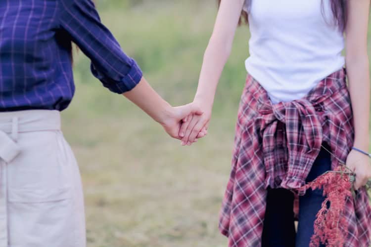 Two women holding hands.