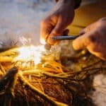 A close-up of a man starting a fire