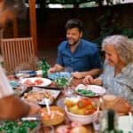 A multigenerational family eating together outdoors.