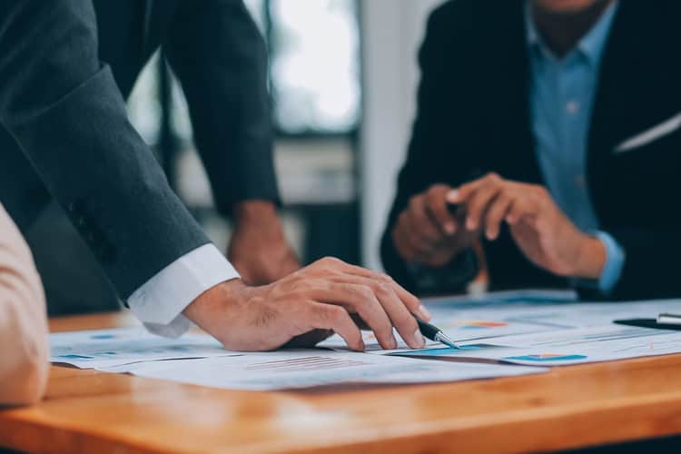 People in a business meeting reviewing paperwork.